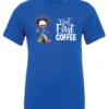 blue coffee addict t-shirt featuring a disheveled young woman with surprised face in pajamas and a cup of coffee, it says but first coffee