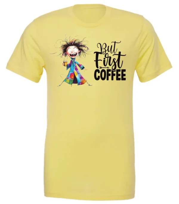 yellow coffee addict t-shirt featuring a disheveled young woman with surprised face in pajamas and a cup of coffee, it says but first coffee