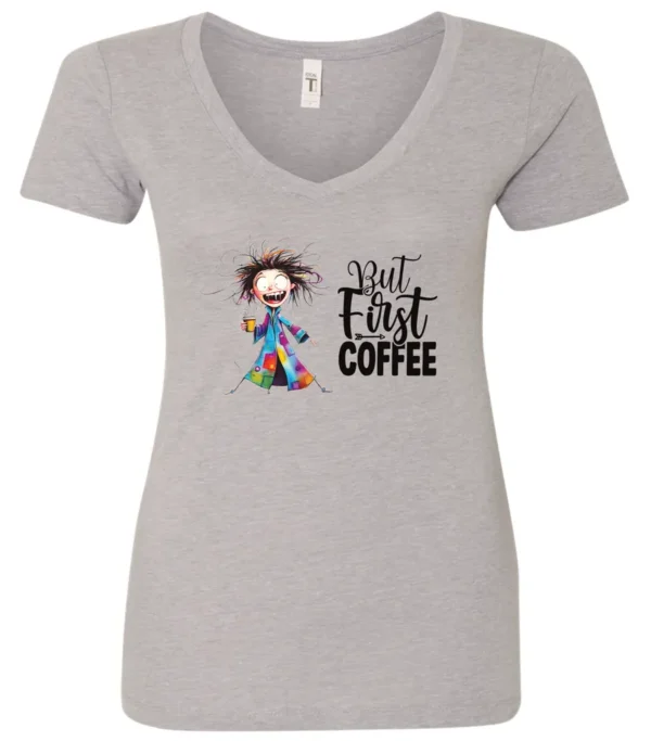 silver coffee addict v-neck t-shirt featuring a disheveled young woman with surprised face in pajamas and a cup of coffee, it says but first coffee
