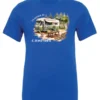 blue camping t-shirt featuring an old model camper in the woods with a table and chairs outside, and it says I’d rather be camping