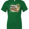 green camping t-shirt featuring an old model camper in the woods with a table and chairs outside, and it says I’d rather be camping