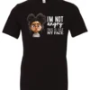 black funny sarcastic t-shirt featuring a young black girl with two hair buns, glasses and angry face saying I'm not angry, this is just my face