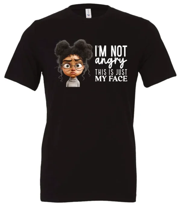 black funny sarcastic t-shirt featuring a young black girl with two hair buns, glasses and angry face saying I'm not angry, this is just my face