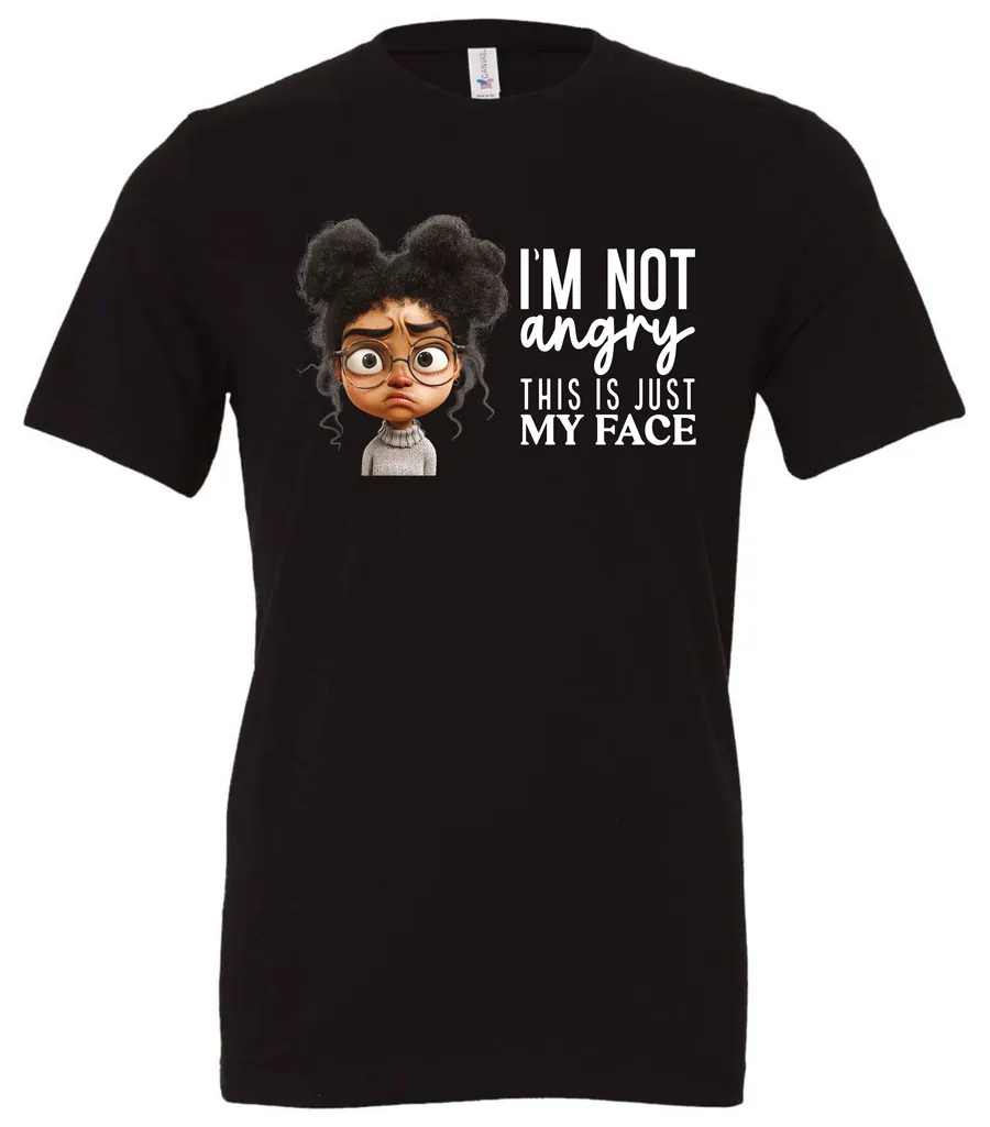 black funny sarcastic t-shirt featuring a young black girl with two hair buns, glasses and angry face saying I'm not angry, this is just my face