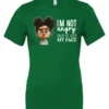 green funny sarcastic t-shirt featuring a young black girl with two hair buns, glasses and angry face saying I'm not angry, this is just my face