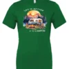green campfire t-shirt featuring a camper by the lake, campfire on, and mountains with a sunset in the background, and it says life is better at the campfire.