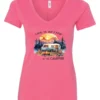 pink campfire v-neck t-shirt featuring a camper by the lake, campfire on, and mountains with a sunset in the background, and it says life is better at the campfire.